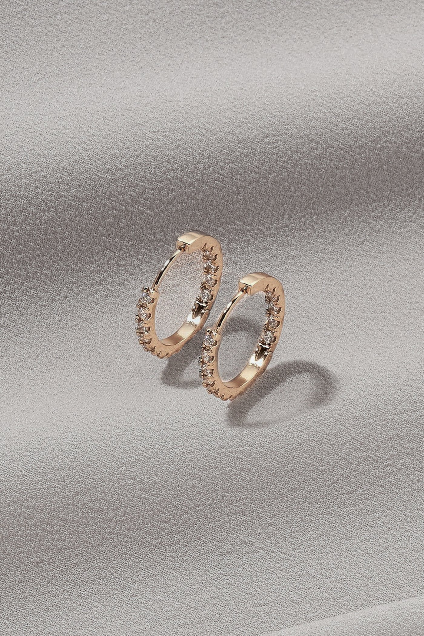 A basic shot of gold, mini hoop earrings with gem details and a regular clasp.