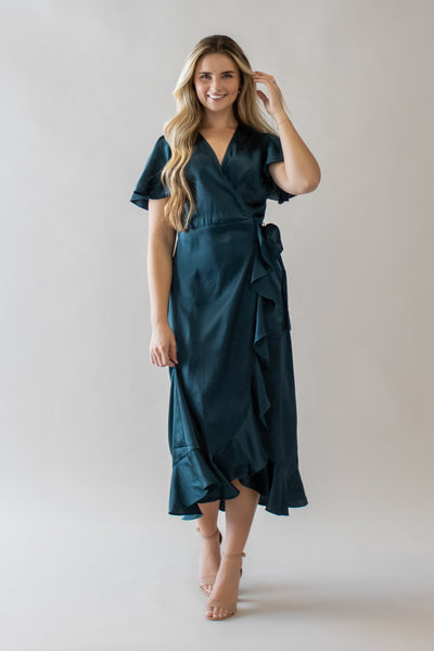 This is a modest dress with a pretty teal color and a wrap closure.