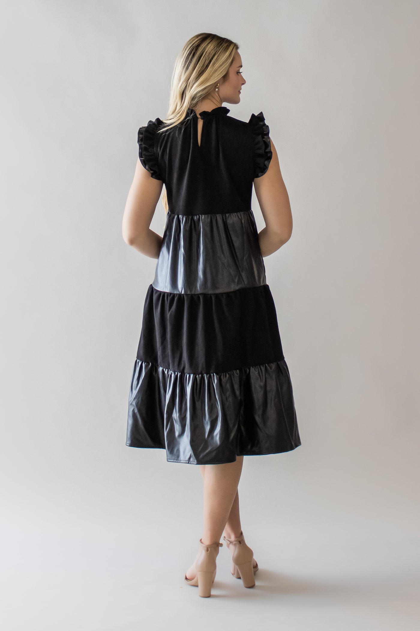 This is a black modest dress with pleather and fabric as well as a mock neck.
