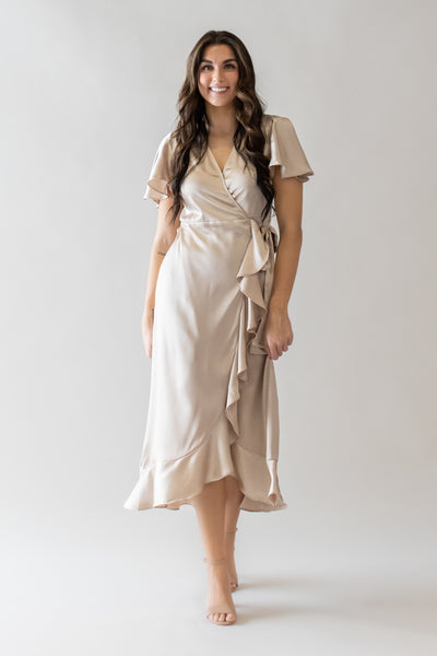 This is a modest dress with a wrap bodice and ruffle details.