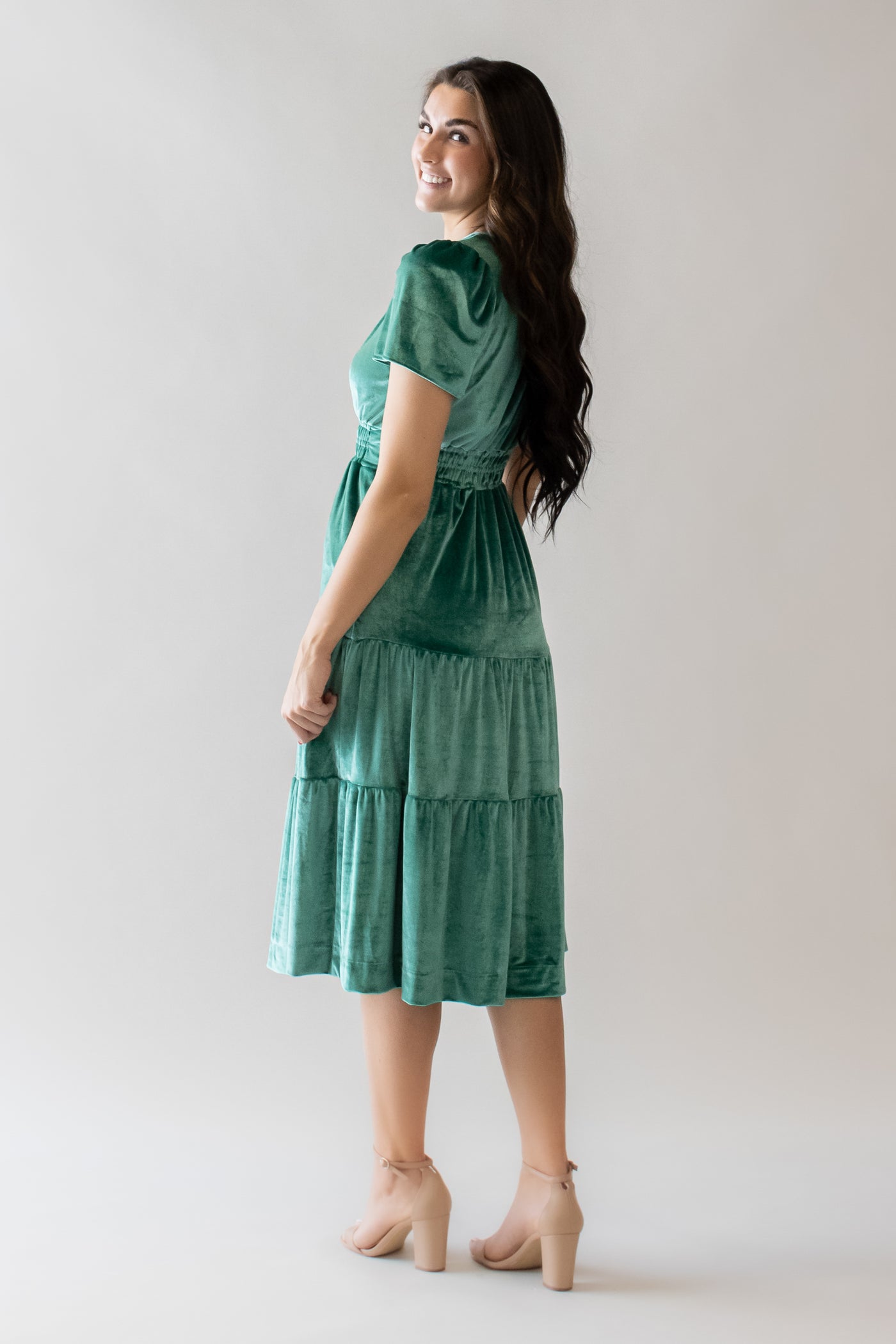 This is the back of a bright  green midi length skirt modest dress with velvet details.
