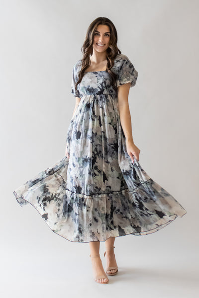 This is a modest dress with black and cream floral details and a ruffle detail at the bottom of the skirt.