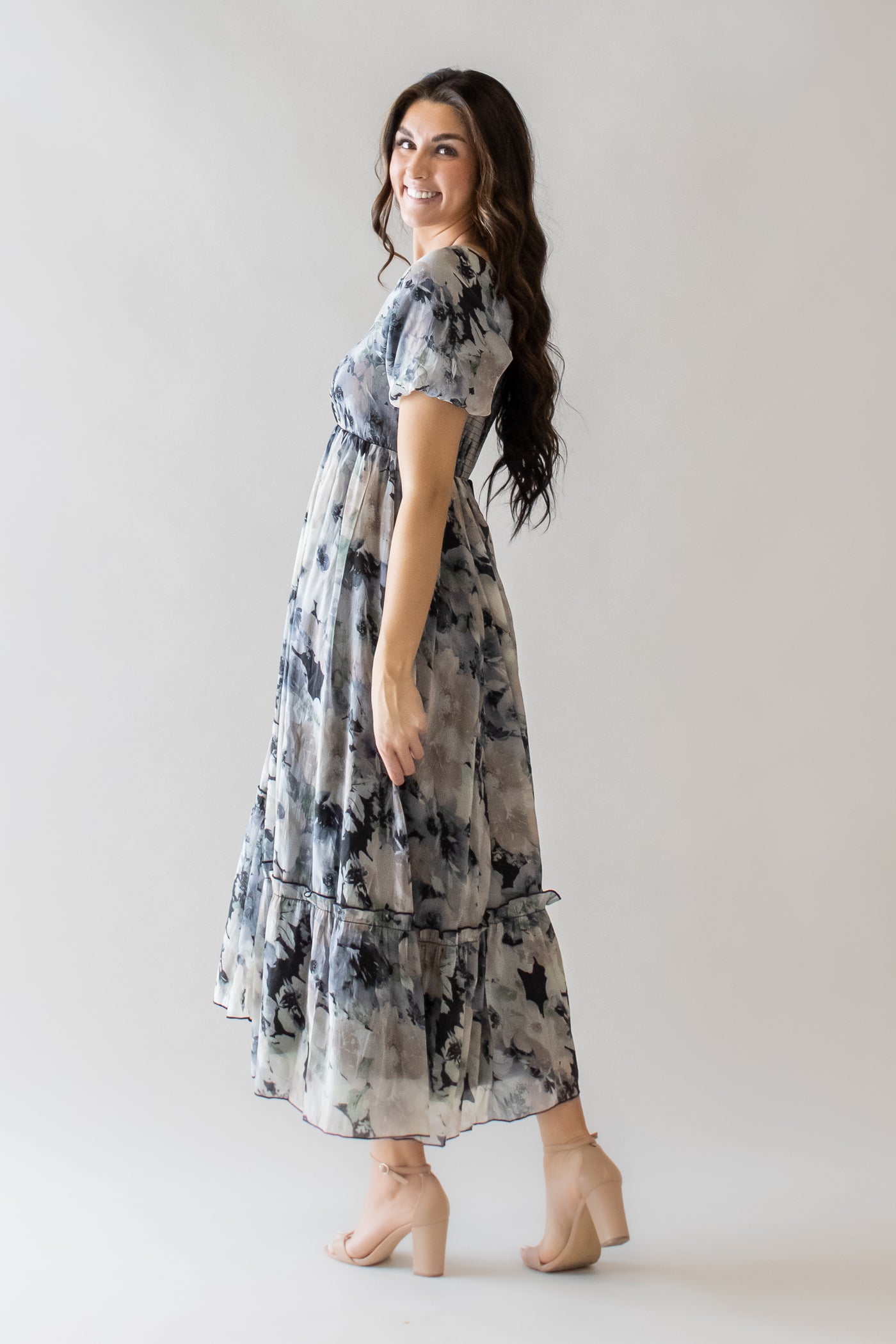 This is a modest dress with a square neckline and black floral details.