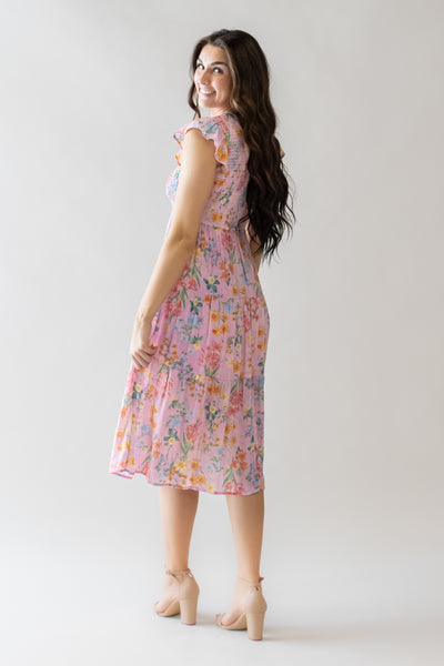 This is a modest dress with a pink color and multi colored florals
