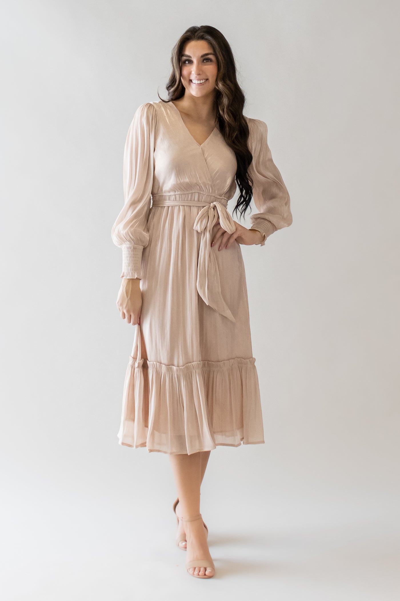 This is a modest dress with a tie in the front and midi length skirt and long sleeves.