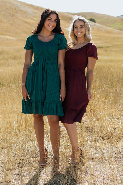 A shot of two friend posing together in matching modest dresses.