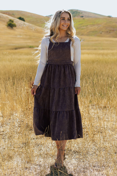 A front shot of a modest dress with a corduroy fabric and tiered skirt. 
