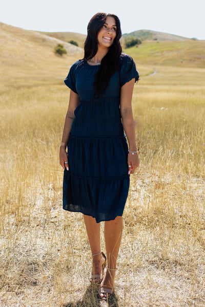 Another front shot of a blue modest dress with a scoop neckline and a textured fabric.