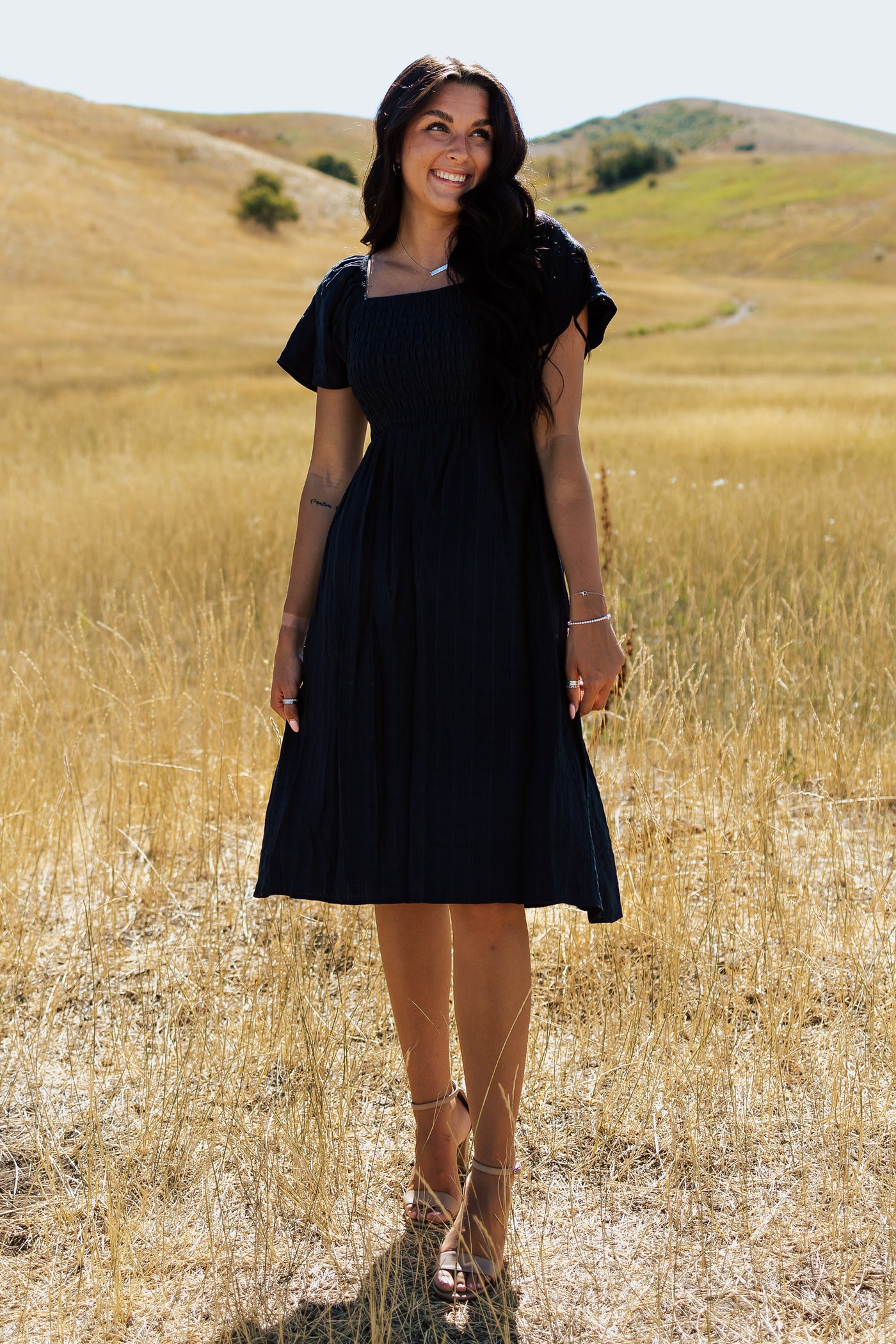 Another front shot of a navy modest dress with a square neckline and a defined waistline. 