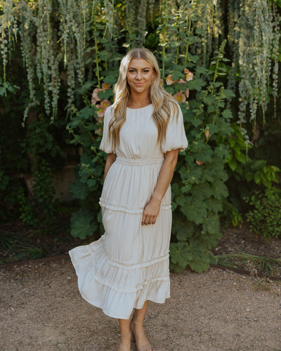 An alternate front shot of this modest ivory dress with puff sleeves, layered tiers and a high neckline.