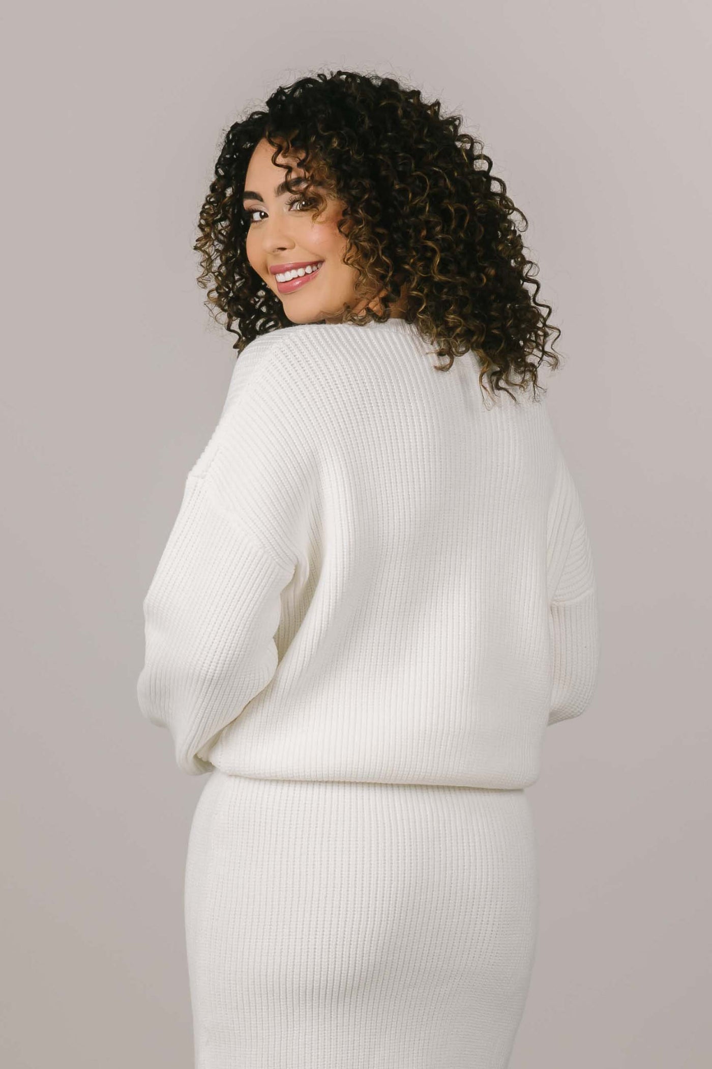 This is the back of a white sweater that is a part of a modest clothing set.