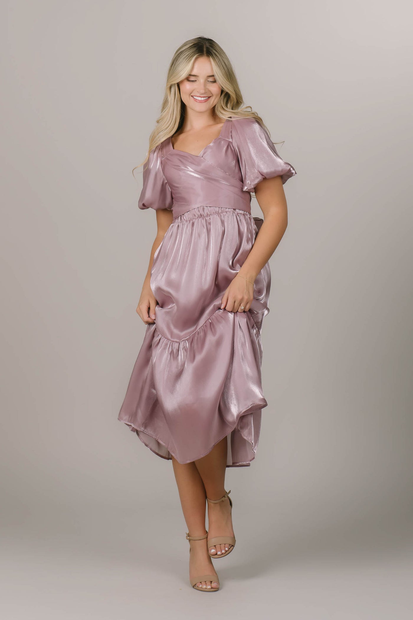 This is a modest bridesmaid dress with puff sleeves and a midi length skirt.