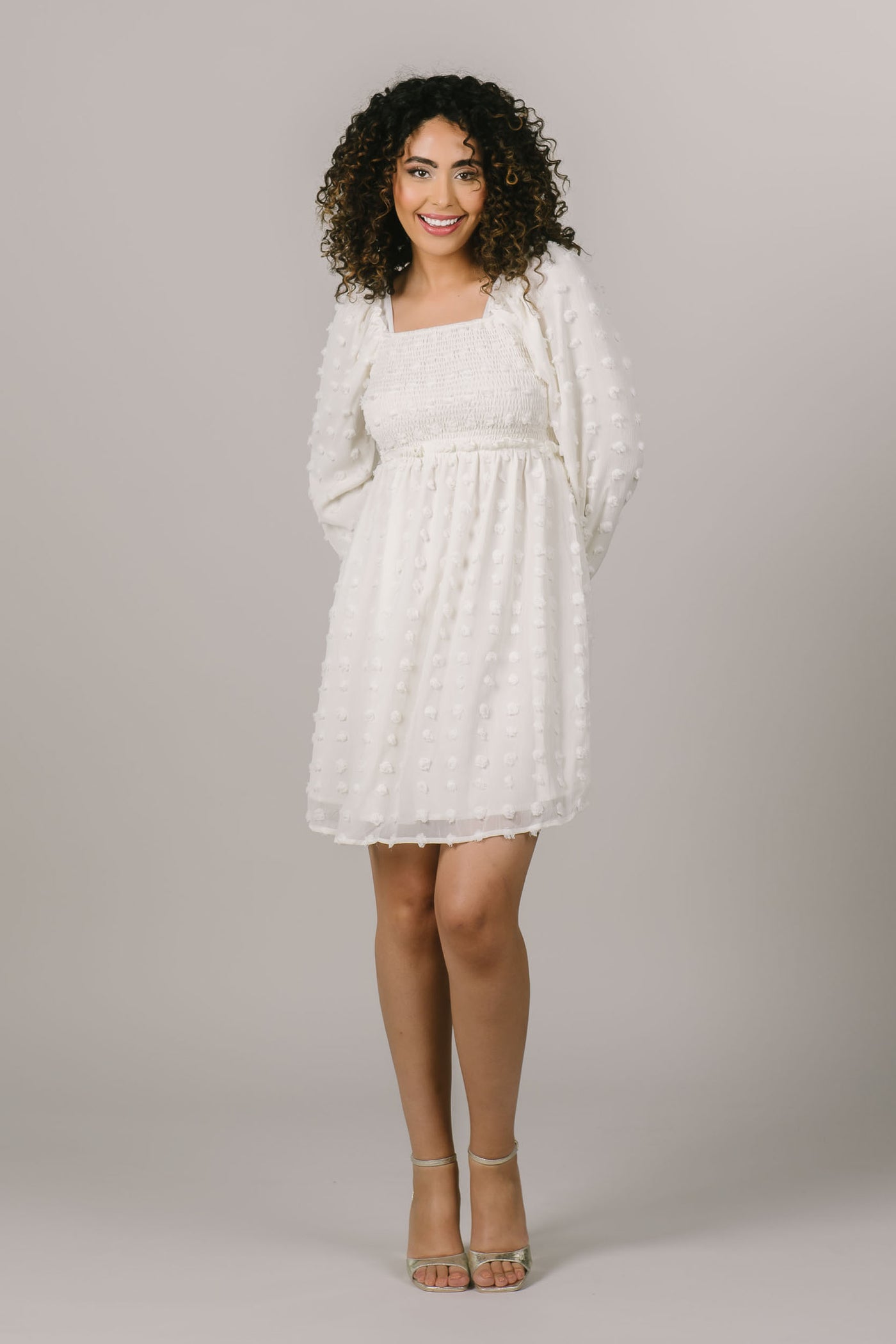 This is a modest dress with polka dot details and perfect as a white getaway dress for brides.