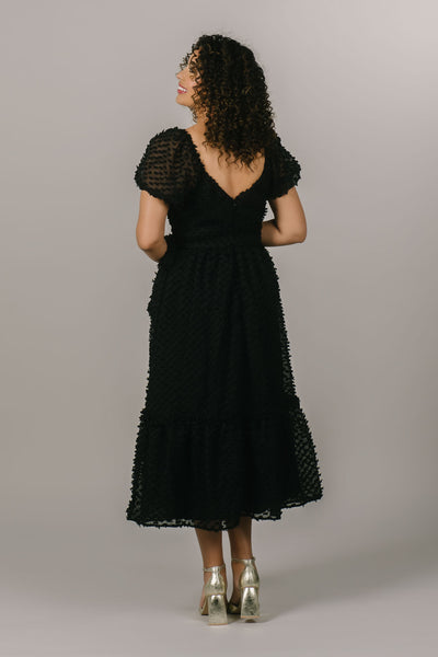 This black modest dress is perfect for everyday wear and has fun polka dot details.