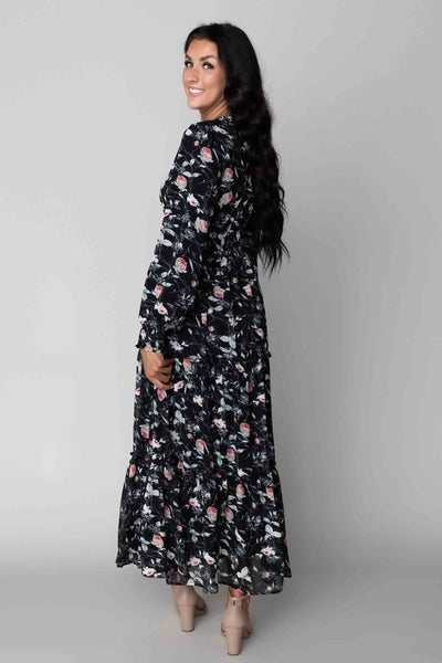 This modest dress is a black color with floral details and a maxi skirt.