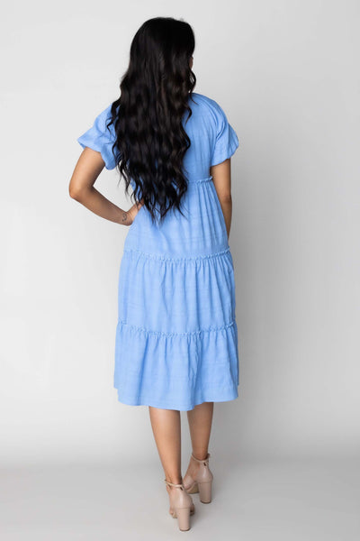 This is a modest dress with a textured fabric and bright blue color.