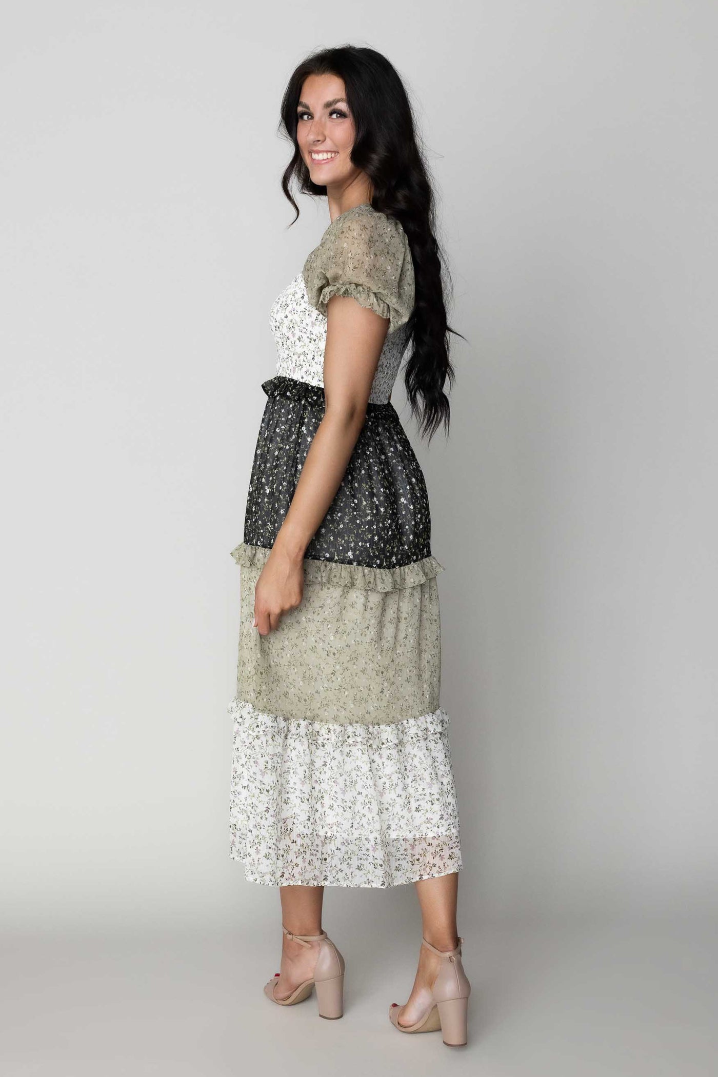 This is a side shot of a modest dress with green, white and black details.