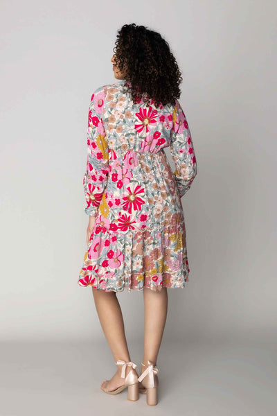 This modest dress features a v neckline, defined waist, and bold colorful florals.