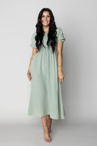 This is a modest wedding dress perfect as a green bridesmaid dress with a smocked details and a midi skirt.