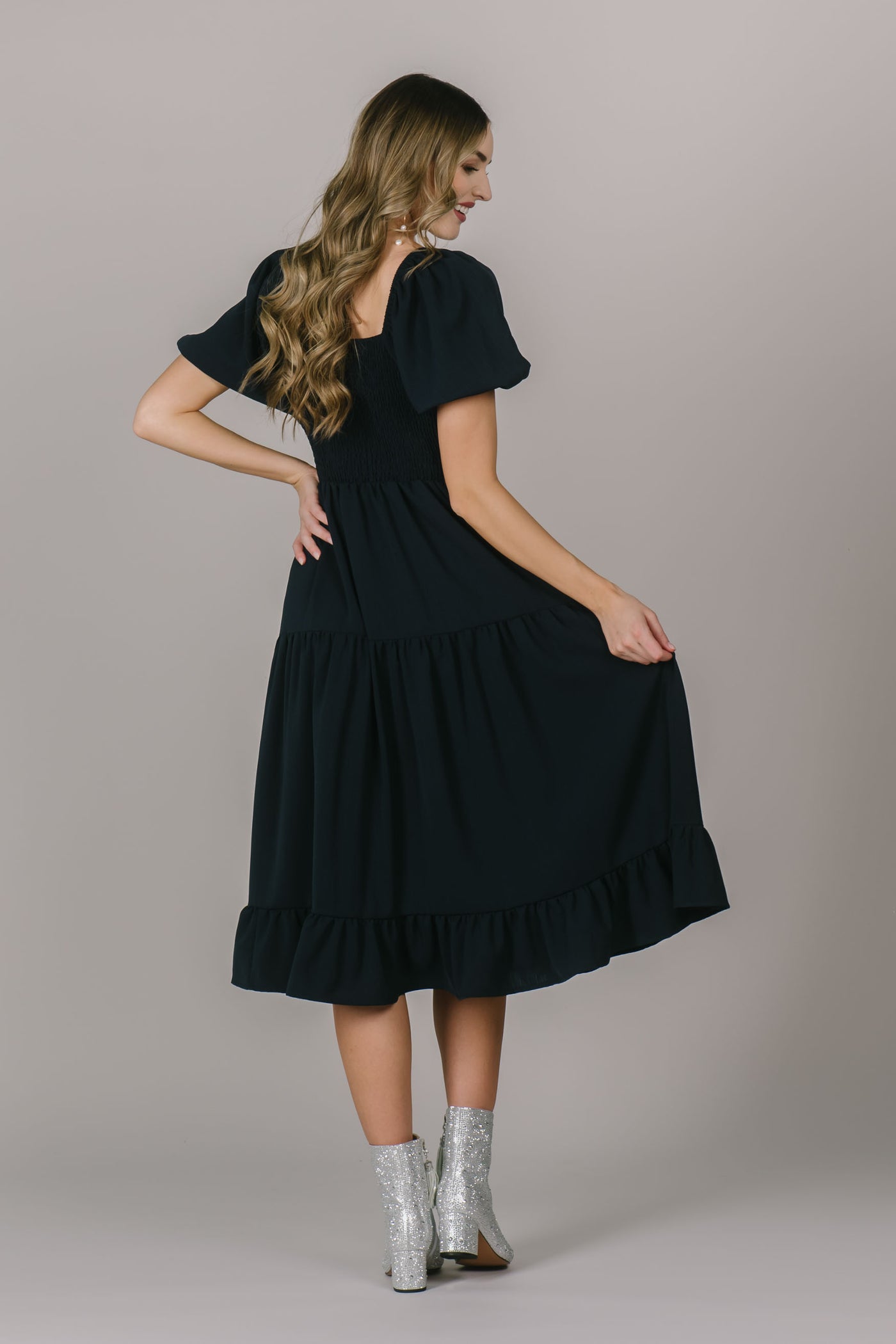 Back of modest dress with a cute square neck, a beautiful navy color, and the most flattering midi length.