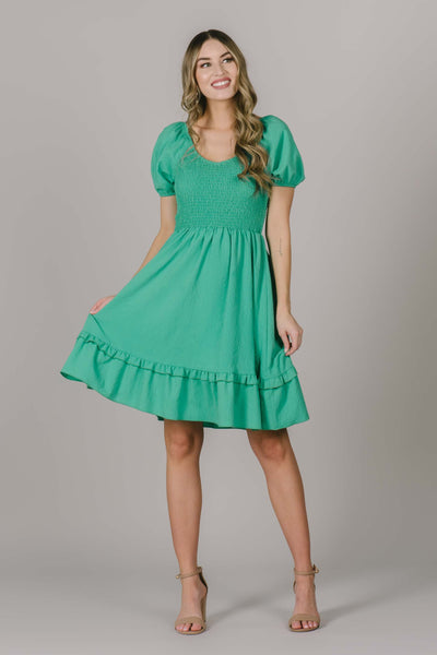 Modest dress in Utah in the cutest green color for spring. This dress has cute puff sleeves, smocking across the chest, and a scoop neckline.