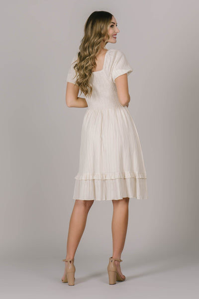 A backshot of this modest dress in Utah that is ivory  with puff sleeves and a textured material