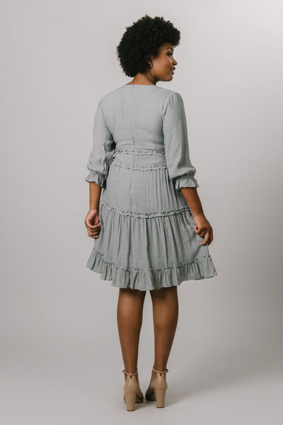 Back shot of a flint grey dress that's tiered with long sleeves. Modest Dresses - Modest Clothing - Everyday Modest Dresses - Bridesmaid Modest Dresses. 