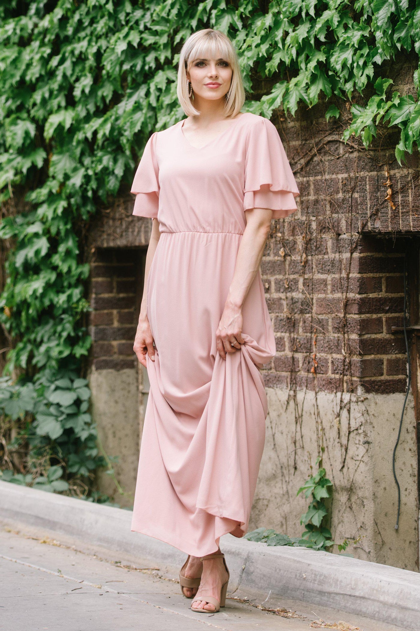 Floor length formal wear or bridesmaid dress with tiered butterfly sleeves in blush pink from a Salt Lake City bridal shop.