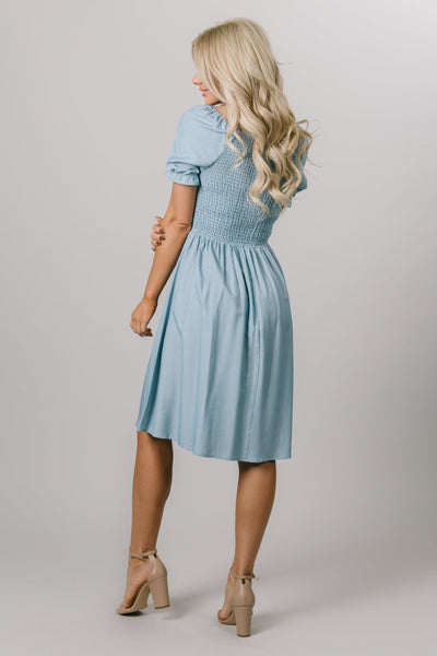 Modest Dresses - Everyday Modest Dresses - Bridesmaid Modest Dresses. The back of the dresses features a beautiful smocked bodice with puff sleeves. The color of the dress is Blue / Faded Denim Sheen. 