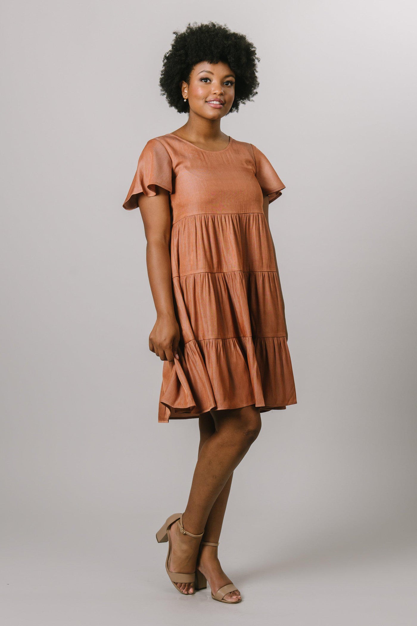 A tiered dress with a scoop neck and flutter sleeves in burnt ginger.Modest Dresses - Modest Clothing - Everyday Modest Dresses - Bridesmaid Modest Dresses
