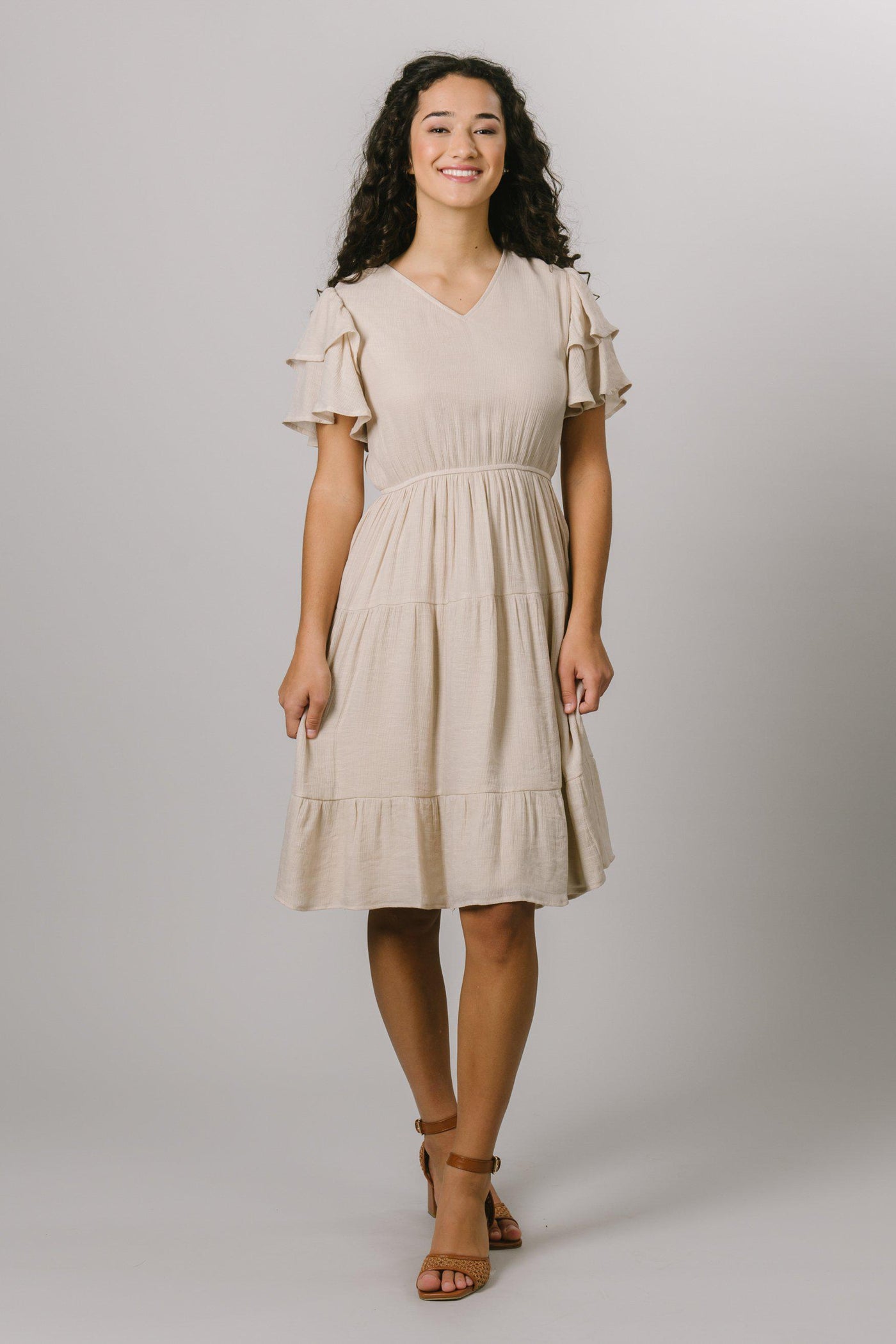 Our modest v-neck everyday dress features a layered flutter sleeve and a tiered textured pattern in pearl. Modest Dresses - Modest Clothing - Everyday Modest Dresses - Bridesmaid Modest Dresses.