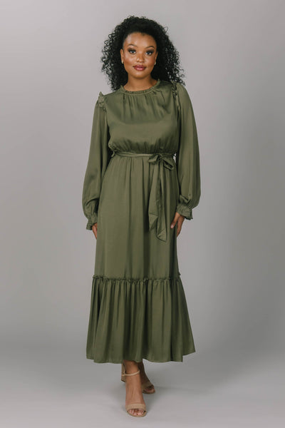 Front view of olive modest bridesmaid dress. This dress is ankle length, tiered skirt. It ties at the waist and has bishop sleeves. 
