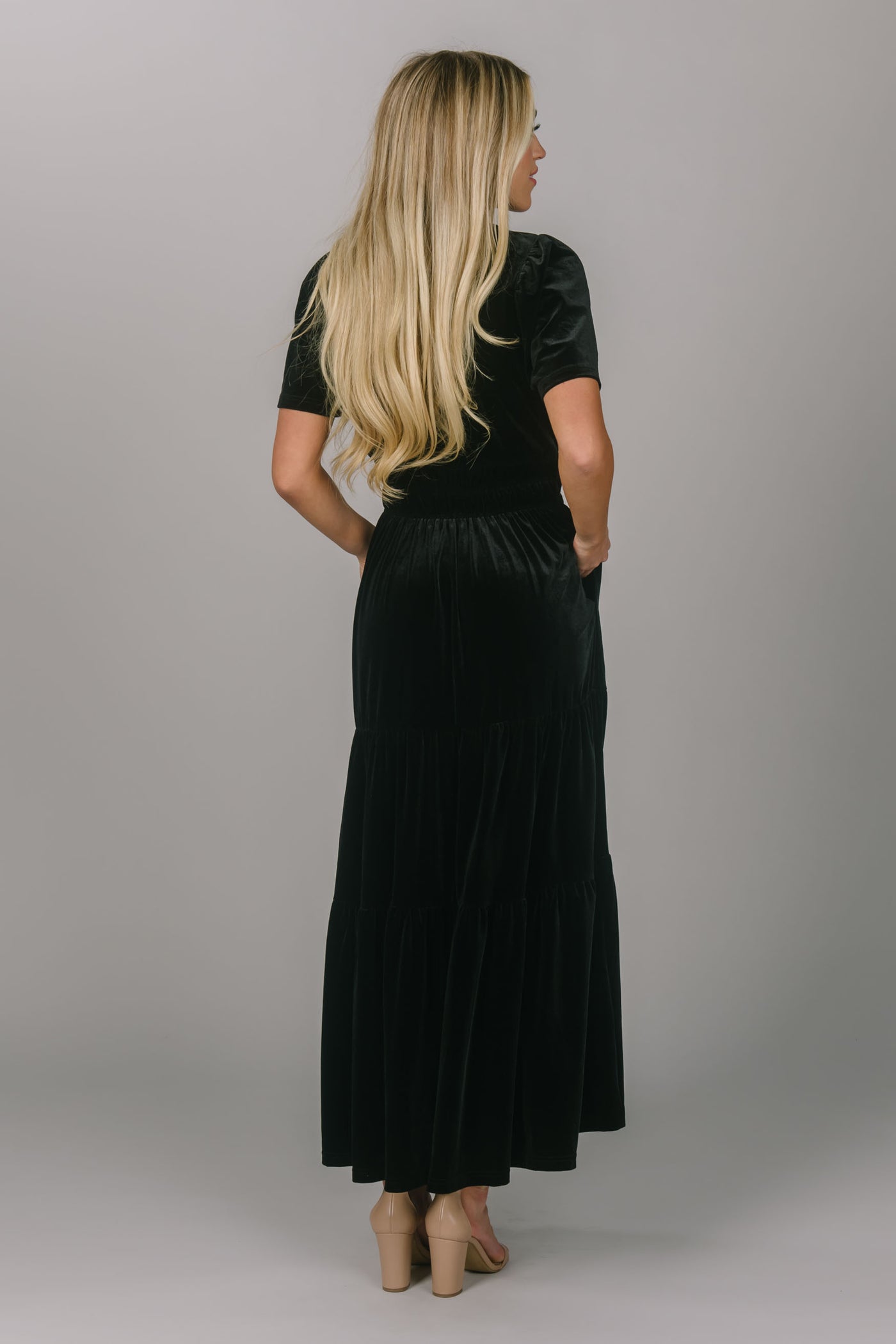 Modest everyday and bridesmaid black colored dress. This dress is velvet, has a v-neckline, and a tiered skirt. This modest dress for women is floor length and super comfortable.