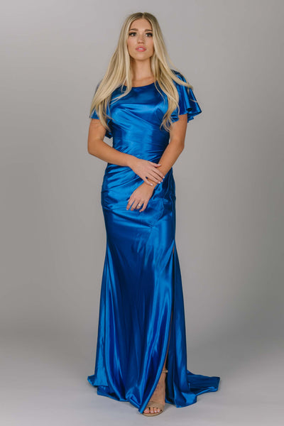 Modest prom dress that is fitted with flutter sleeves. This dress is a royal satin color that has shine. The dress has a scoop neckline and is perfect for any modest prom girl.