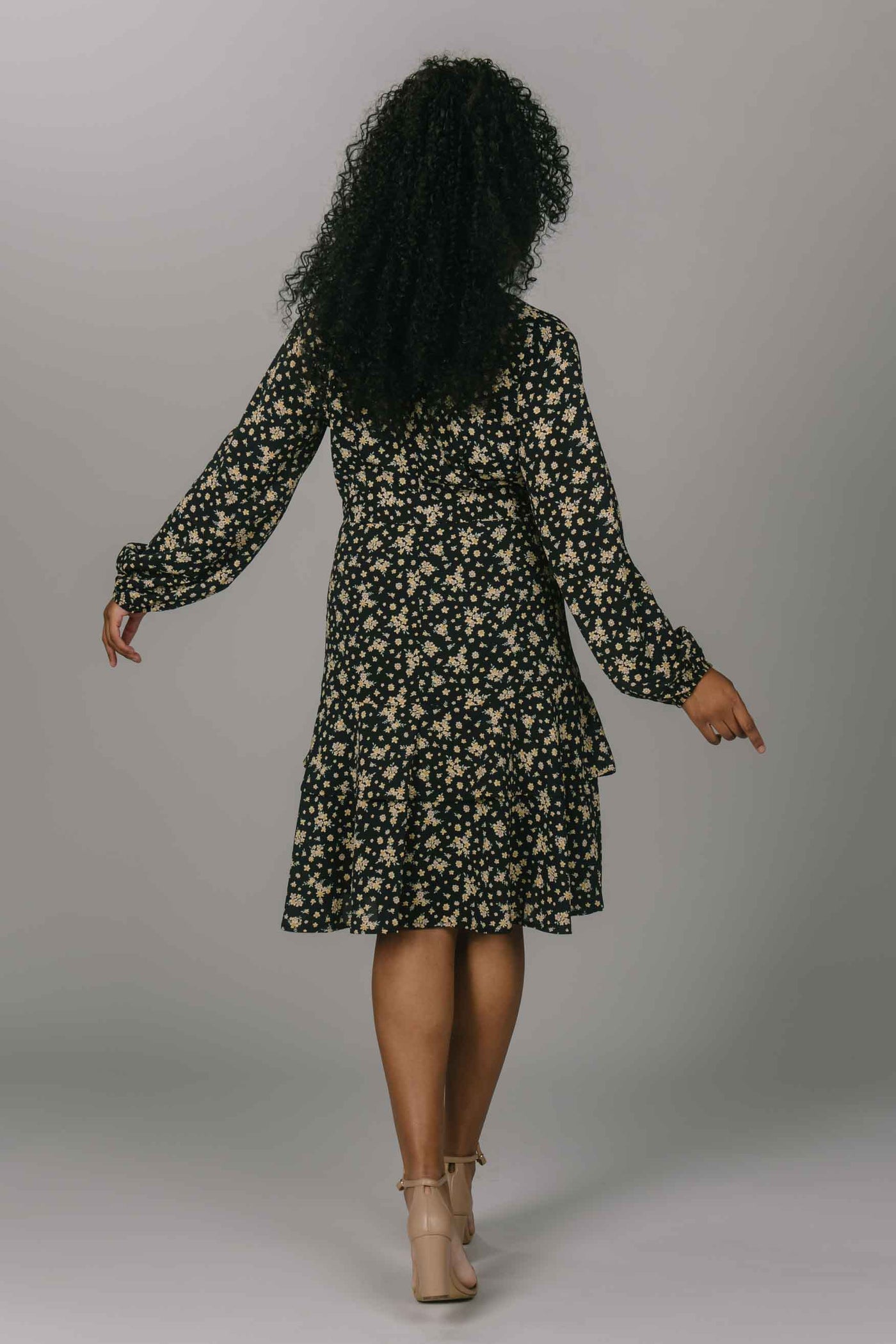 Back view of modest everyday dress with yellow flowers. It has a v-neckline and long sleeves. This dress is knee length and is perfect for the modest woman.