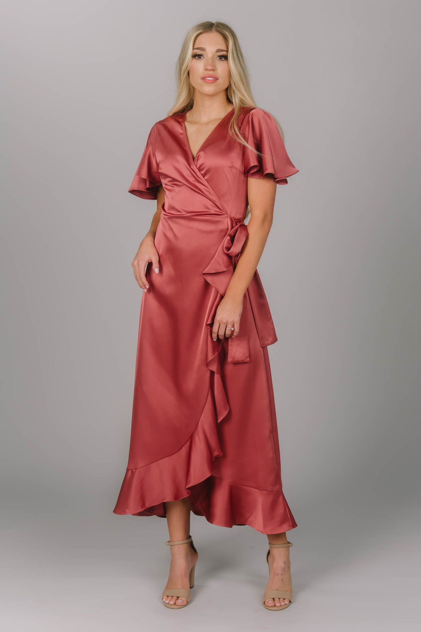 Front view of silk modest bridesmaid dress. It is a wrap style dress with ruffles and gorgeous flutter sleeves. This is the perfect modest dress for all body types. 