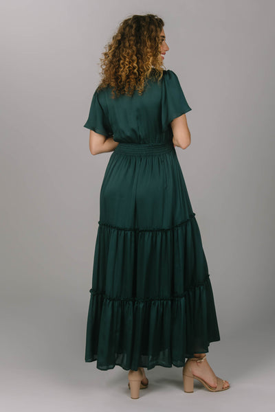 Back view of the perfect green modest bridesmaid dress. It has a v-neckline, flutter sleeves, and tiered skirt. It has an extra shine on the fabric to make your modest bridesmaids really stand out.