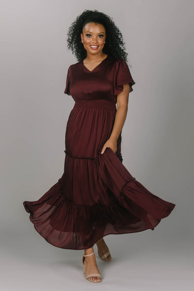 Modest bridesmaid dress with v neckline and flutter sleeves. This dress is a zinfandel color with a tiered skirt. This makes for the perfect modest bridesmaid dress for any season. 