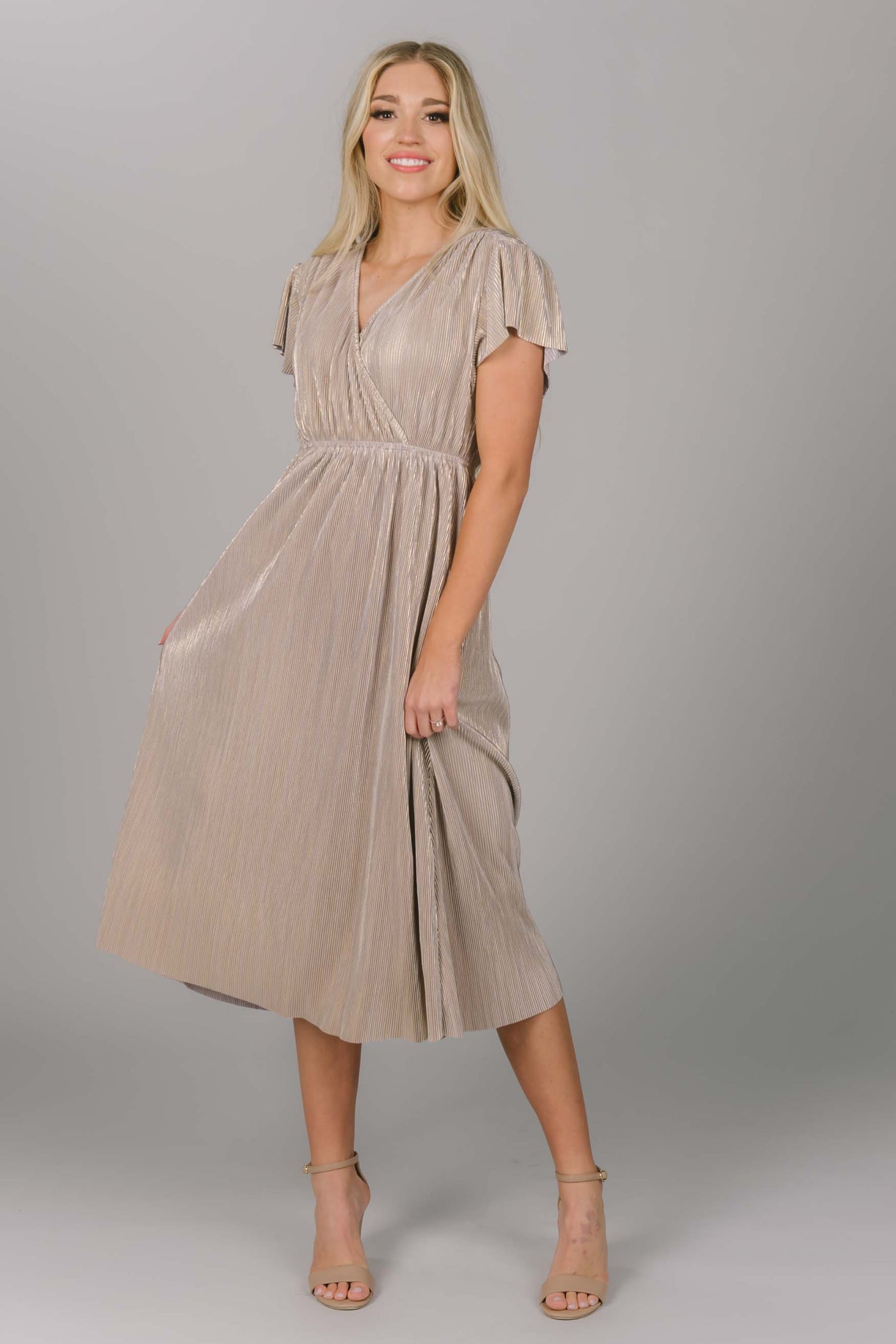 Front view of metallic modest bridesmaid dress. This dress hits mid-calf and is a v-neckline. The sleeves are flutter sleeve style. This grey/gold color makes the perfect bridesmaid dress. 