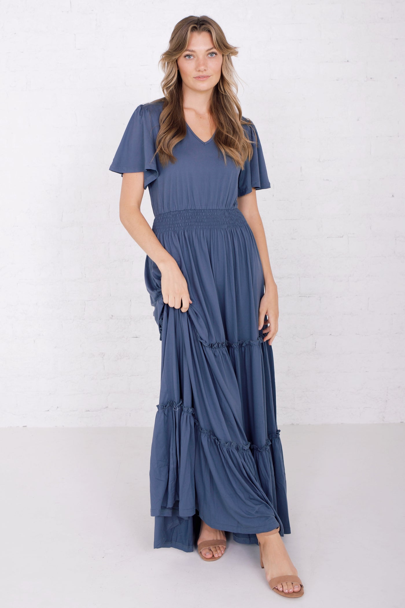 A Midi dress in the color cove night shadow with a smocked waist and tiered bottom. Modest Clothing - Modest Dresses - Modest Bridesmaid Dresses