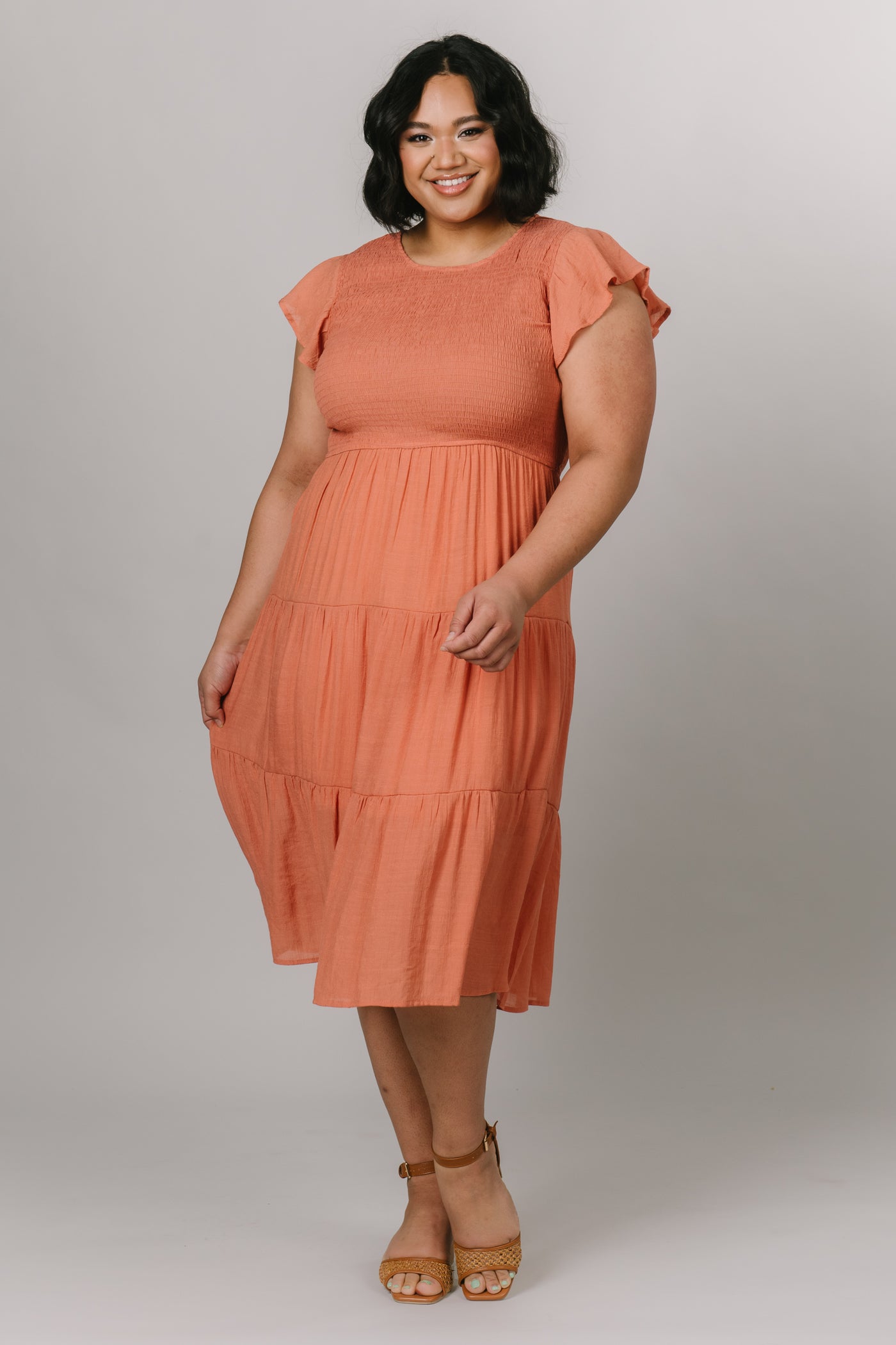 Plus size model in short sleeves dress with a smocked bodice and in the color dusty apricot. Modest Dresses - - Everyday Dresses - Modest Prom Dress - Formalwear Modest Dresses - Bridesmaid Modest Dresses.