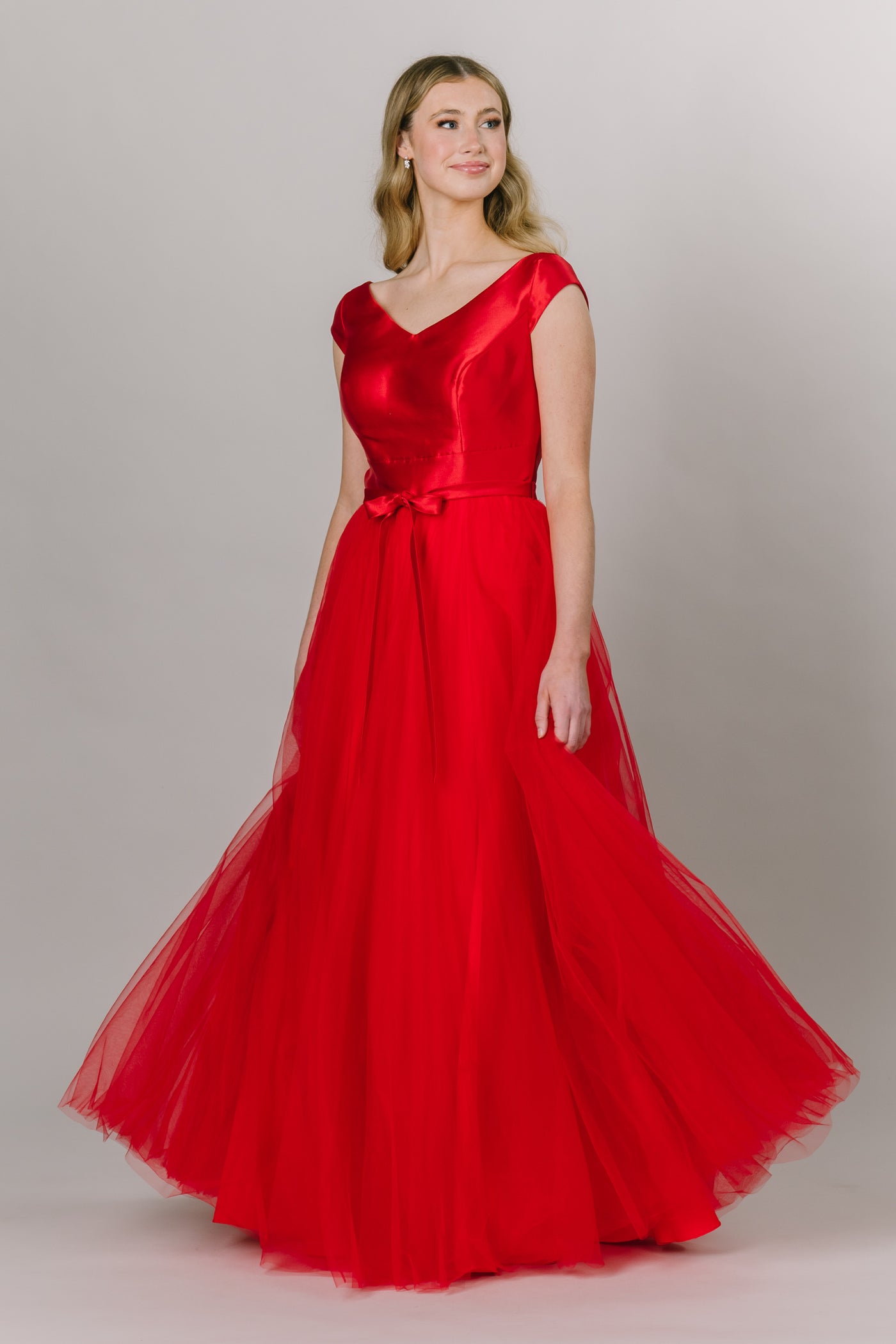 Modest Dresses - Modest Prom Dress - Formalwear Modest Dresses - Bridesmaid Modest Dresses. Red ballgown with a v neckline and cap sleeves and a bow belt and tulle bottom