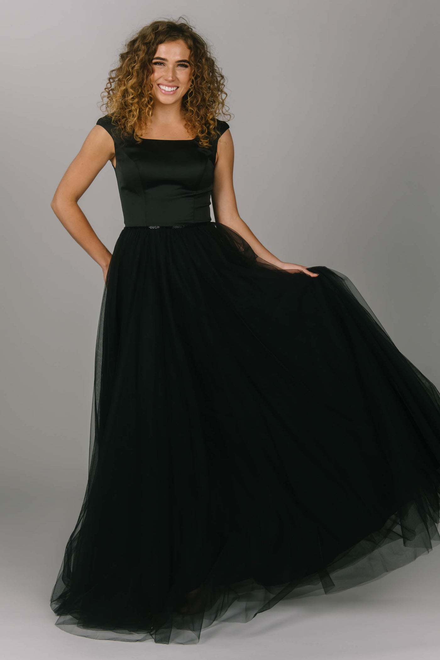 Black modest prom dress with tulle skirt. This a-line dress has cap sleeves and a square neckline. Beautiful modest prom dress. 